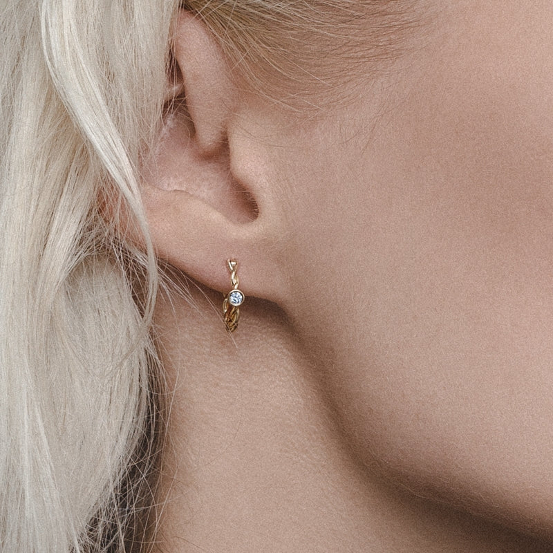 twisted golden hoop earrings with diamonds