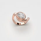 Organic rose gold ring with oval diamond on a light gray background